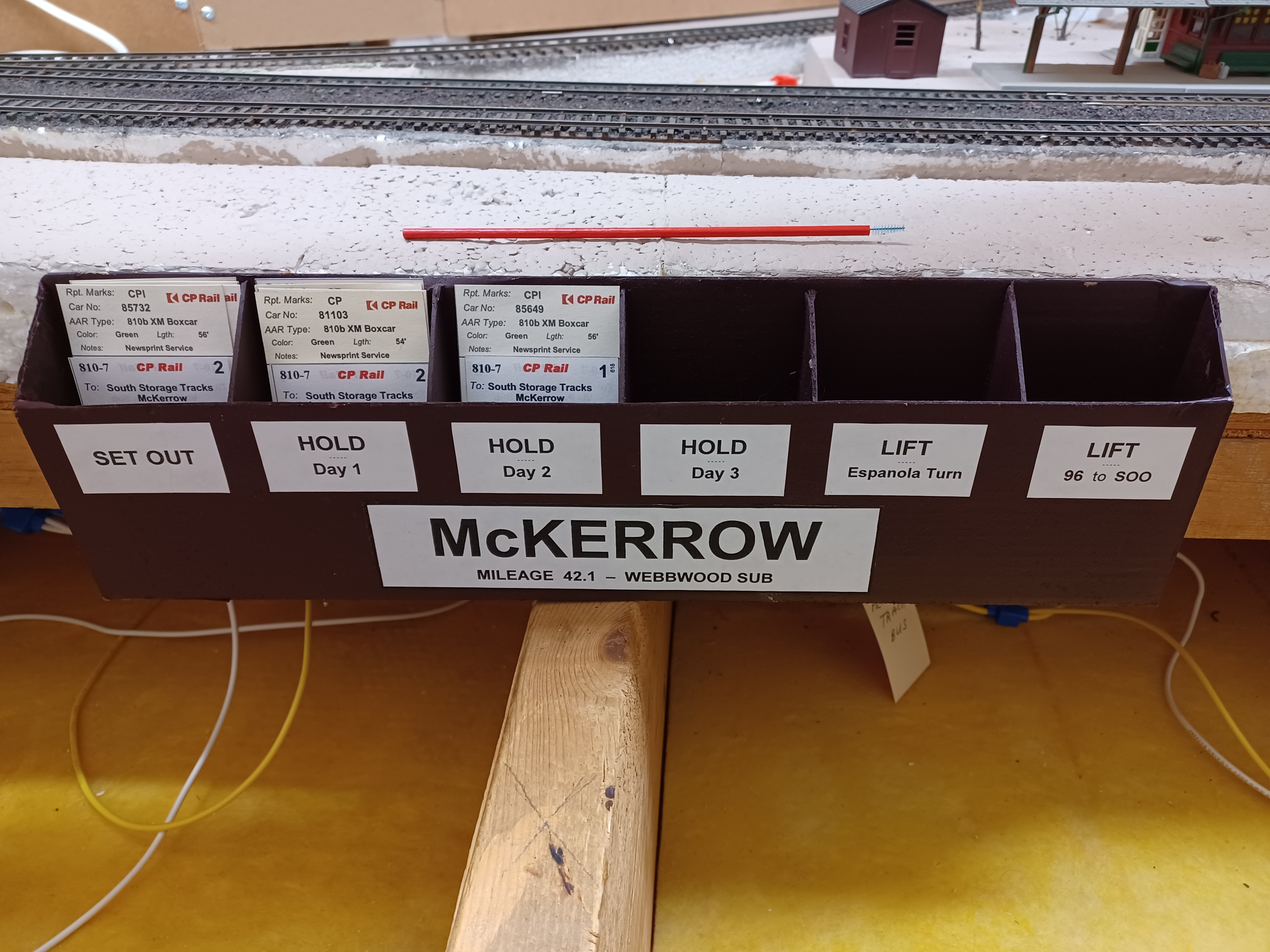 A waybill file box is located anywhere where cars are switched and spotted. In this example, McKerrow Ont. sees CP paper-service boxcars stored for use at the nearby E.B. Eddy paper mill in Espanola. Cars switched into the storage tracks here have their waybills placed into the 'Setout' pocket. These orders are then rotated through the 'Hold' pockets as determined by waybill (simulating the customer's lag in requesting cars to load). Finally the car is ready to 'Lift' - either an empty being requested by E.B. Eddy for their mill (picked up by the Espanola Turn) - or a loaded car dropped here by the outbound turn, which is heading for the US Midwest (via S.S.Marie) and must be lifted by local train #96 heading for the Soo.
